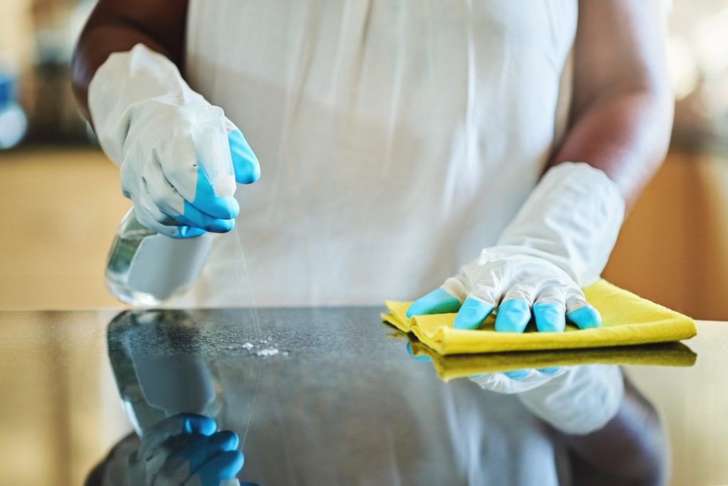 Woman cleaning a kitchen counter at home