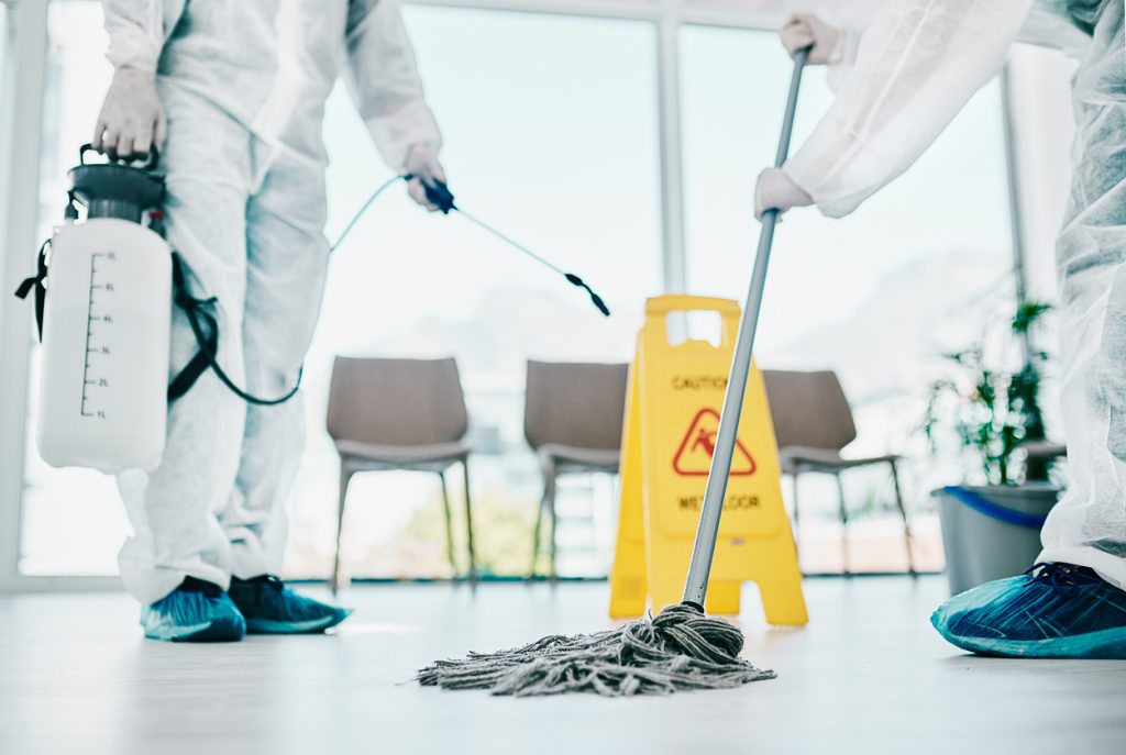 Shot of healthcare workers wearing hazmat suits and sanitising a room during an outbreak