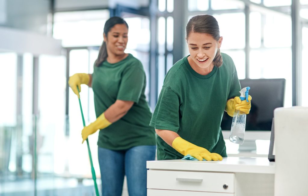 Shot of two young woman cleaning a modern office